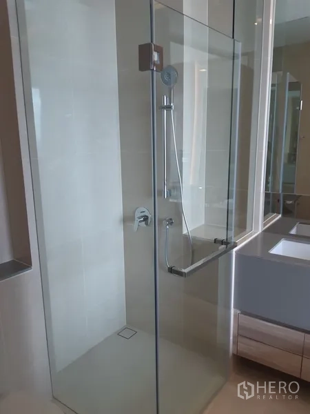Condominium for rent or sale in Watthana, Bangkok - Enclosed glass shower with handheld showerhead in contemporary bathroom.