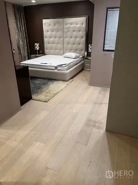 Detached House for rent in Wang Thonglang, Bangkok - Spacious bedroom with padded headboard, platform bed, and warm wood floors.