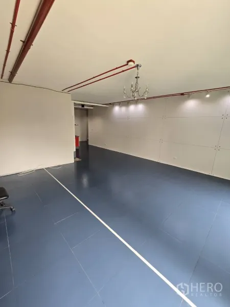 办公空间 出租在Watthana, Bangkok - 宽敞办公区，吊灯、白色墙面、蓝色瓷砖地和天花喷淋管。