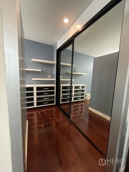 Townhouse for rent or sale in Chatuchak, Bangkok - Walk-in closet with mirrored sliding doors and built-in drawer storage.