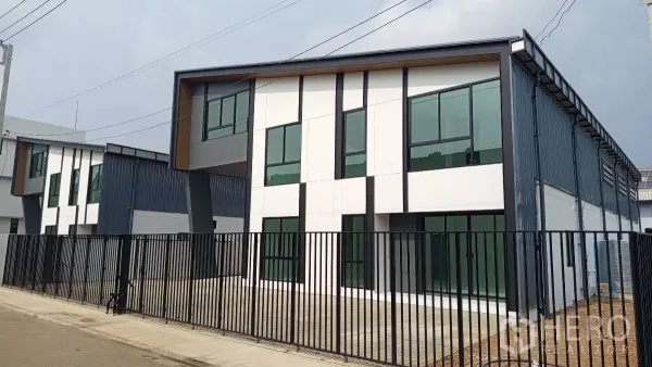 Warehouse for rent or sale in Lam Luk Ka, Pathum Thani - Angled view of the contemporary warehouse facade with large glazing and a private forecourt.