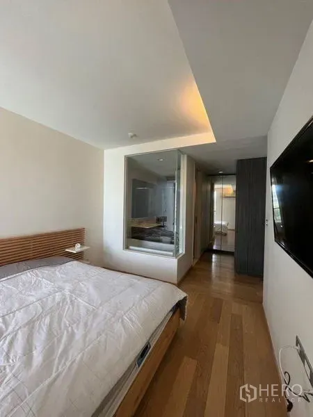 公寓 出租或出售在Watthana, Bangkok - 卧室铺木地板，带玻璃隔断的套内卫浴。