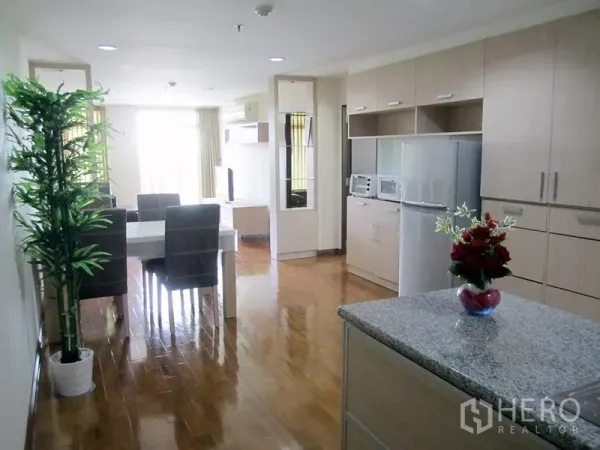 Condominium for rent in Bang Rak, Bangkok - Bright open-plan kitchen and dining with light wood cabinetry, island countertop, and polished wood floors.