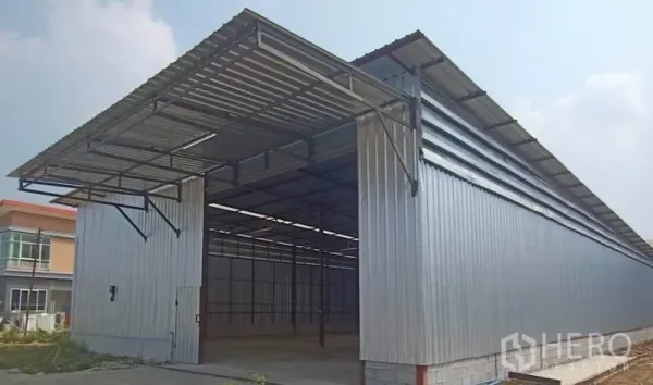 Warehouse for rent in Mueang Samut Sakhon, Samut Sakhon - Metal-clad warehouse exterior with a wide covered loading bay and tall roof.