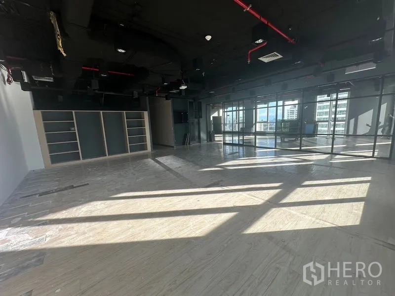 办公空间 出租在Bang Rak, Bangkok - 转角大空间，内置置物架与整面落地玻璃墙。