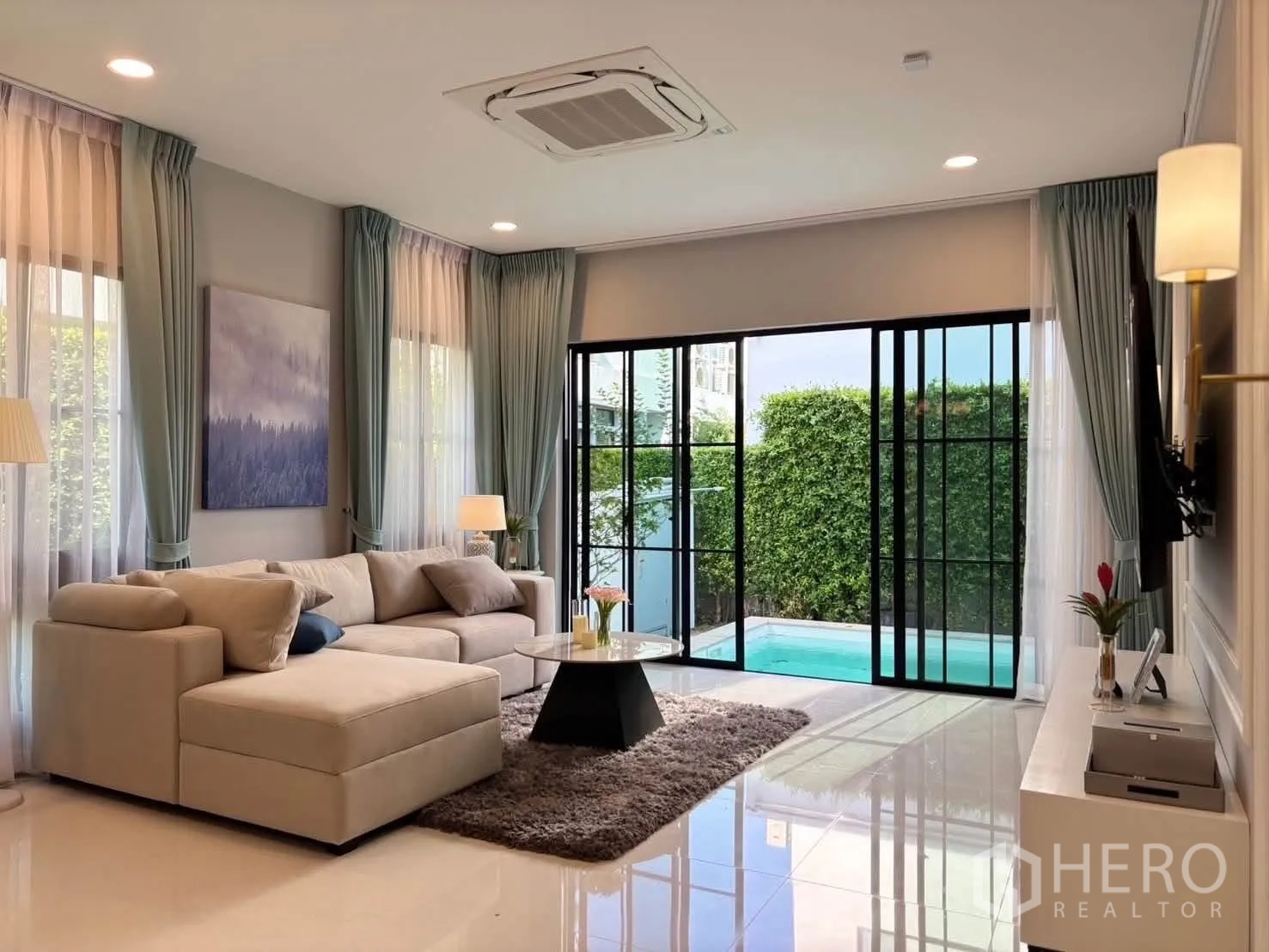 Detached House for rent in Saphan Sung, Bangkok - Bright living room with L-shaped sofa opening to a private pool through sliding glass doors.