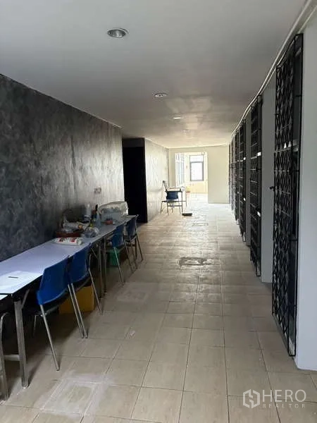 办公空间 出租在Khlong Toei, Bangkok - 长走廊工作区，设桌椅与金属栅门。