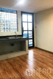 Office Space for rent in Bang Rak, Bangkok - Pantry area with sink, wood-look flooring, gridded window and balcony door.