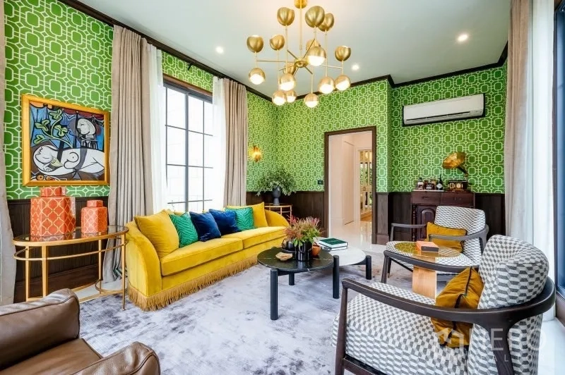 Detached House for sale in Bang Kapi, Bangkok - Chic living room with bold green wallpaper, yellow sofa and a modern chandelier.
