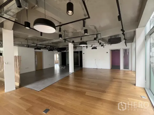 Retail Space for rent in Khlong Toei, Bangkok - Open-plan partly fitted retail or office area with wood flooring, exposed ceiling and track lighting.