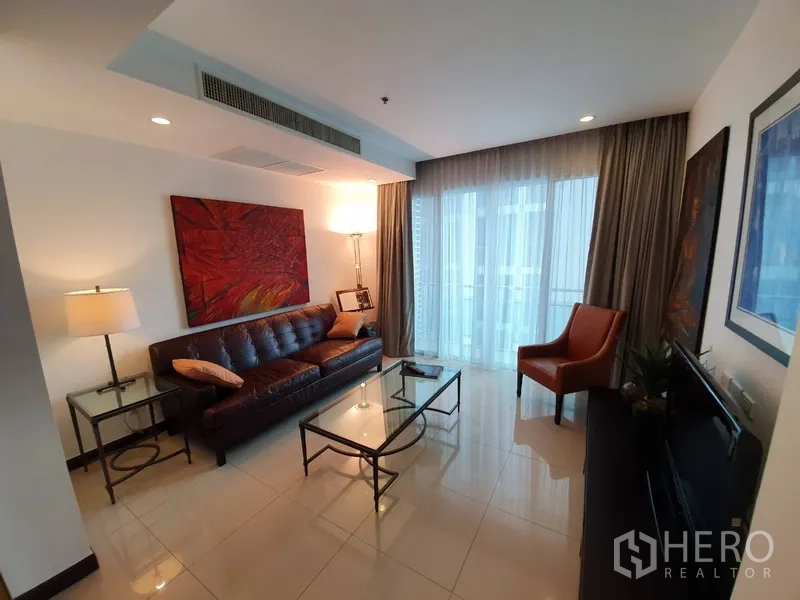 คอนโด ให้เช่าในWatthana, Bangkok - ห้องนั่งเล่นโซฟาหนัง โต๊ะกระจก กลางห้อง พร้อมประตูกระจกสูงจรดเพดาน