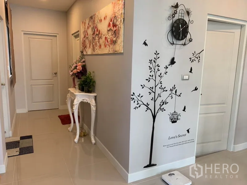 Detached House for rent or sale in Samut Prakan - Hallway with wall art, console table and neutral décor.