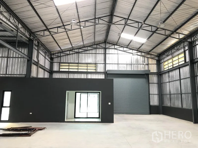 Factory for rent in Bang Yai, Nonthaburi - Open production floor with skylight panels, steel structure and a sliding-glass office entry.