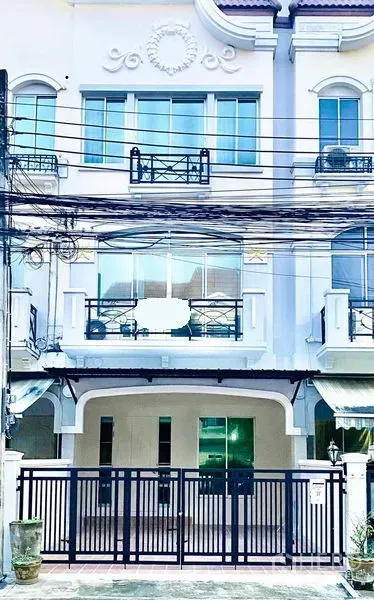 Townhouse for rent in Prawet, Bangkok - Three-storey white townhouse exterior with gated parking and balconies on Srinakarin.