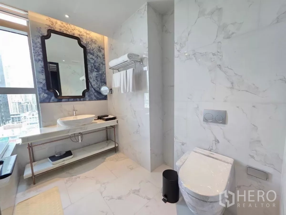 Condominium for rent - Bathroom with glass-enclosed shower and soaking tub beside the window.