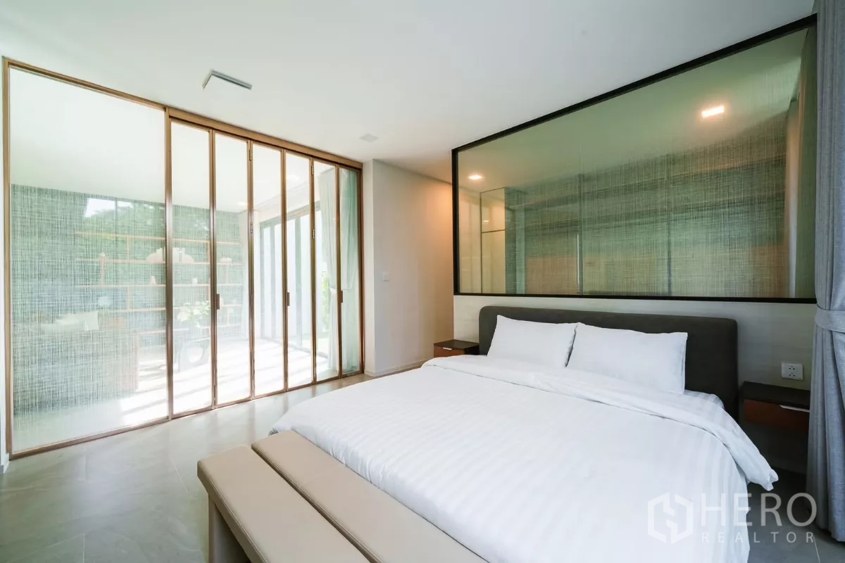 Detached House for rent or sale in Saphan Sung, Bangkok - Serene bedroom with king bed, bench and sliding glass partitions.