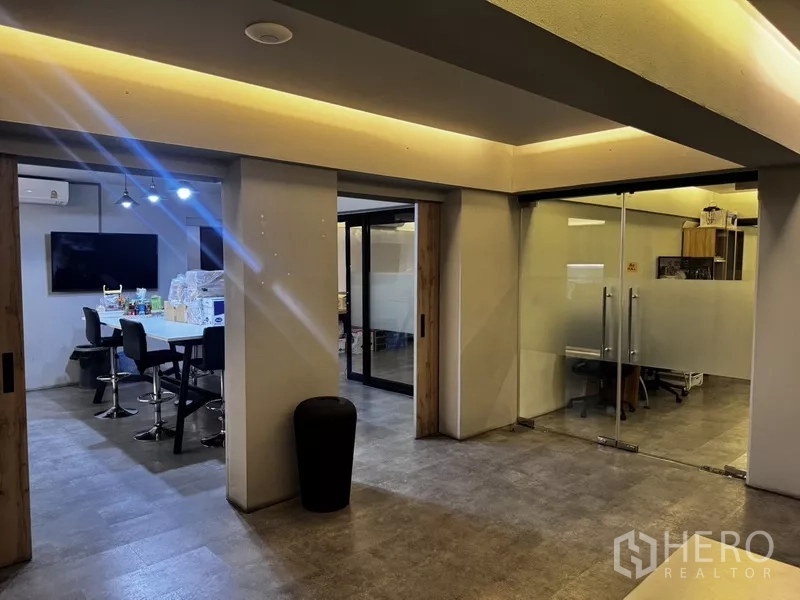 Office Space for rent or sale in Suan Luang, Bangkok - Glass meeting room with white table, TV and mirrored wall under grid ceiling.