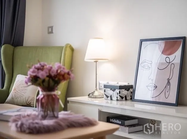 Condominium for sale in Khlong Toei, Bangkok - Styled decor detail with table lamp, artwork, and flowers on a white sideboard.