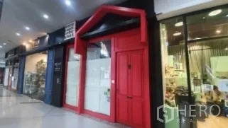 零售空间 出租在Khlong Toei, Bangkok - 室内商场通道上的店面，红色立面与相邻店铺。