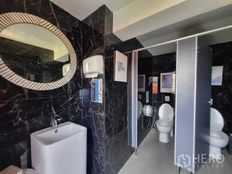 Retail Space for rent in Bang Rak, Bangkok - Modern restroom with black marble walls, sink and private toilet stalls.