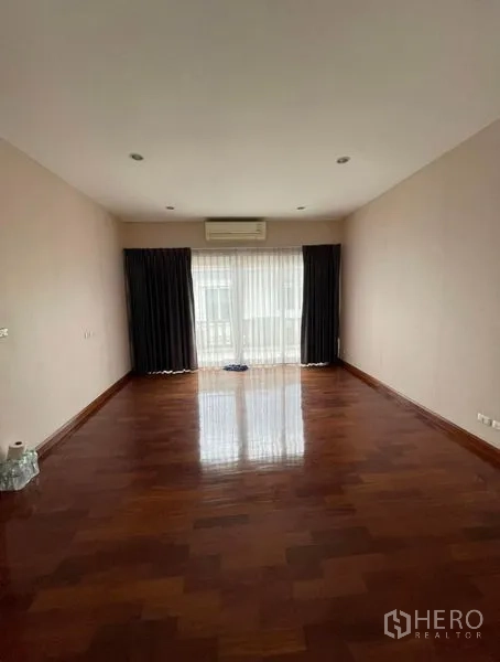 Detached House for rent - Bright bedroom with polished wooden floors, ceiling spotlights, and a wide curtained window.