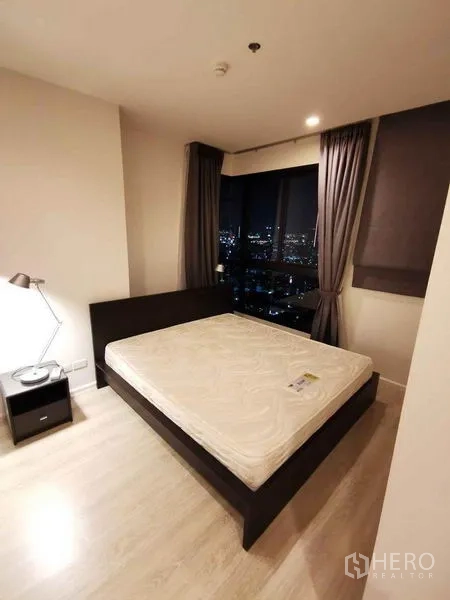 公寓 出租或出售在Din Daeng, Bangkok - 夜景卧室，窗外城市灯火。