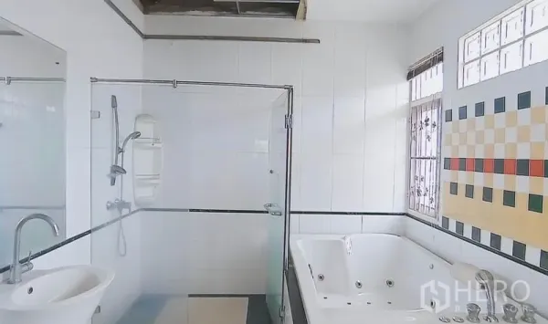 独立式住宅 出售在Bang Kapi, Bangkok - 明亮浴室，玻璃淋浴间、按摩浴缸与瓷砖墙面，带窗采光。