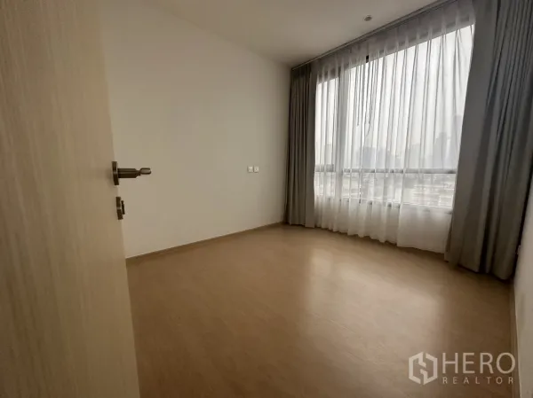 公寓 出租在Watthana, Bangkok - 次卧设大幅窗户与纱帘，木地板