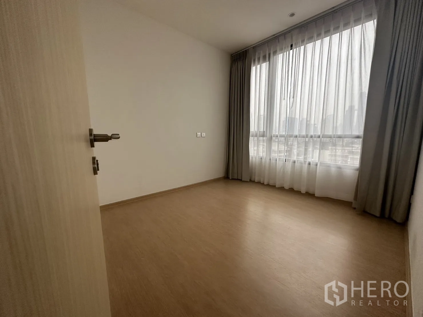 公寓 出租在Watthana, Bangkok - 次卧设大幅窗户与纱帘，木地板