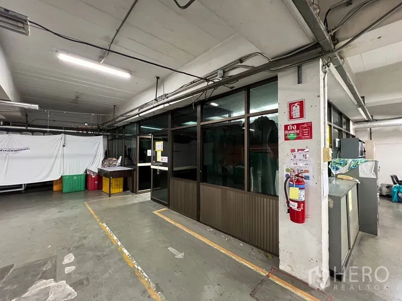 คลังสินค้า ให้เช่าในBang Kapi, Bangkok - มุมภายในพร้อมห้องออฟฟิศกั้นกระจก เดินสายไฟ และถังดับเพลิงในพื้นที่อุตสาหกรรม.