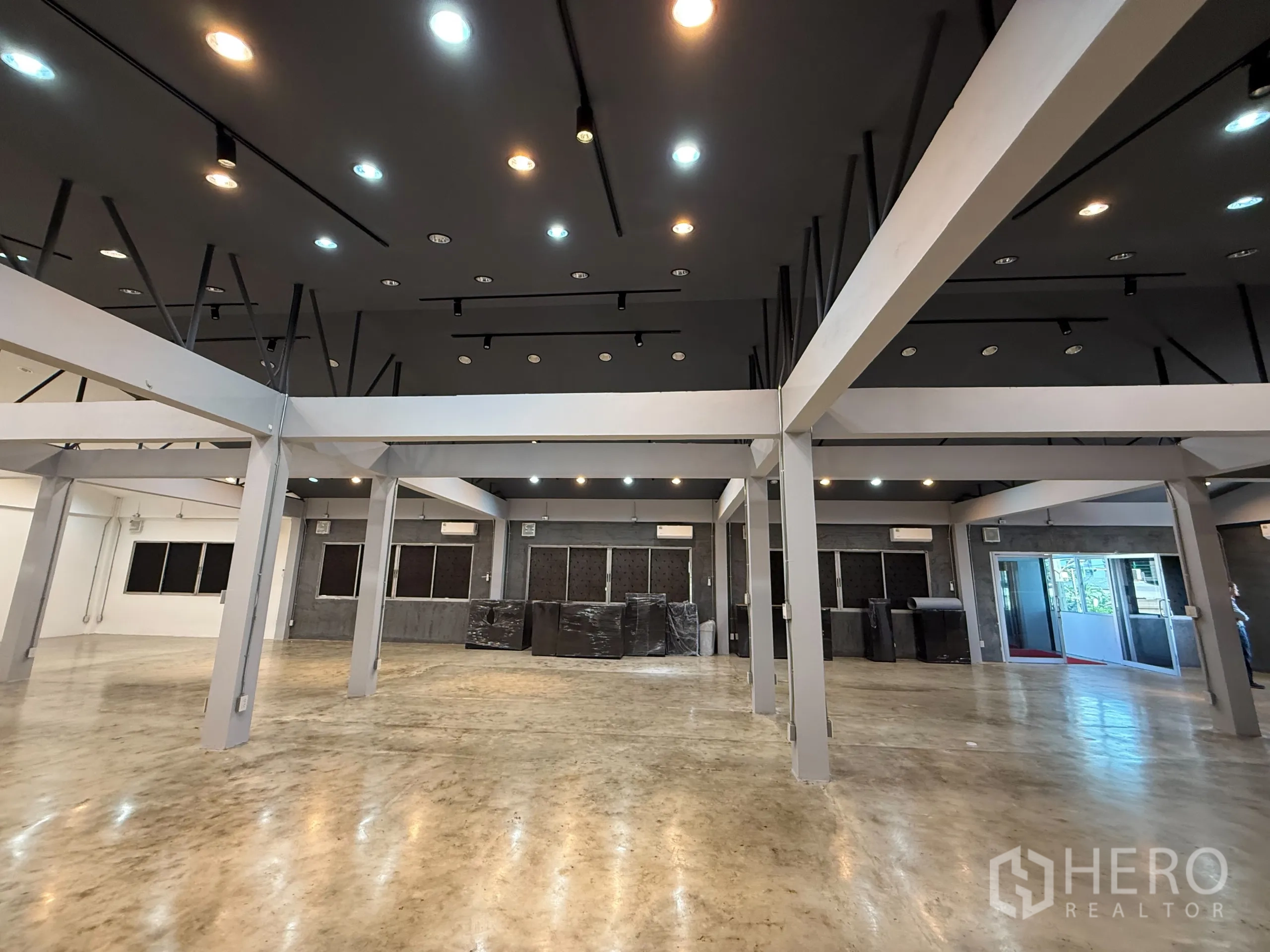 办公空间 出租在Wang Thonglang, Bangkok - 天花与轨道灯细节，柱网结构之上，侧边为推拉玻璃门的开放式办公区。