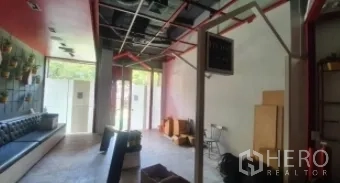 零售空间 出租在Khlong Toei, Bangkok - 开放式零售室内，外露天花与红色管道，大面积玻璃门与内置长椅。