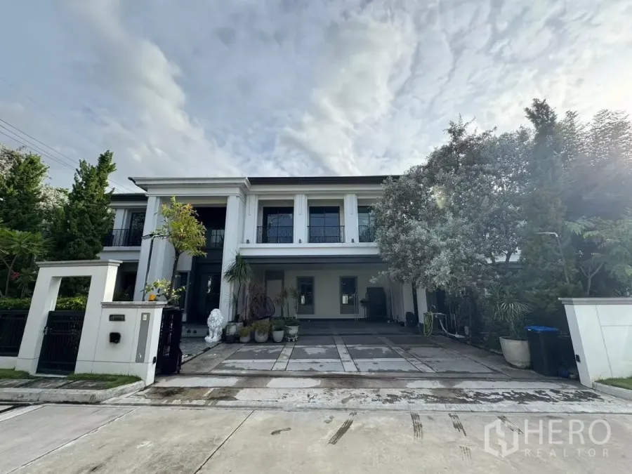 独立式住宅 出售在Mueang Pathum Thani, Pathum Thani - 两层豪华独栋住宅外观，挑高立柱、车道与景观树。