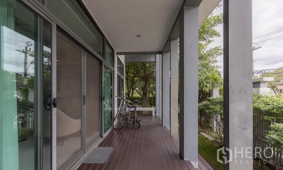 独栋房屋 for rent or sale in Bang Kapi, Bangkok - 带遮蔽的前露台，木地板与推拉落地玻璃门。