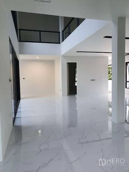 Detached House for rent in Phra Khanong, Bangkok - Double-height living space with white columns and polished marble flooring.