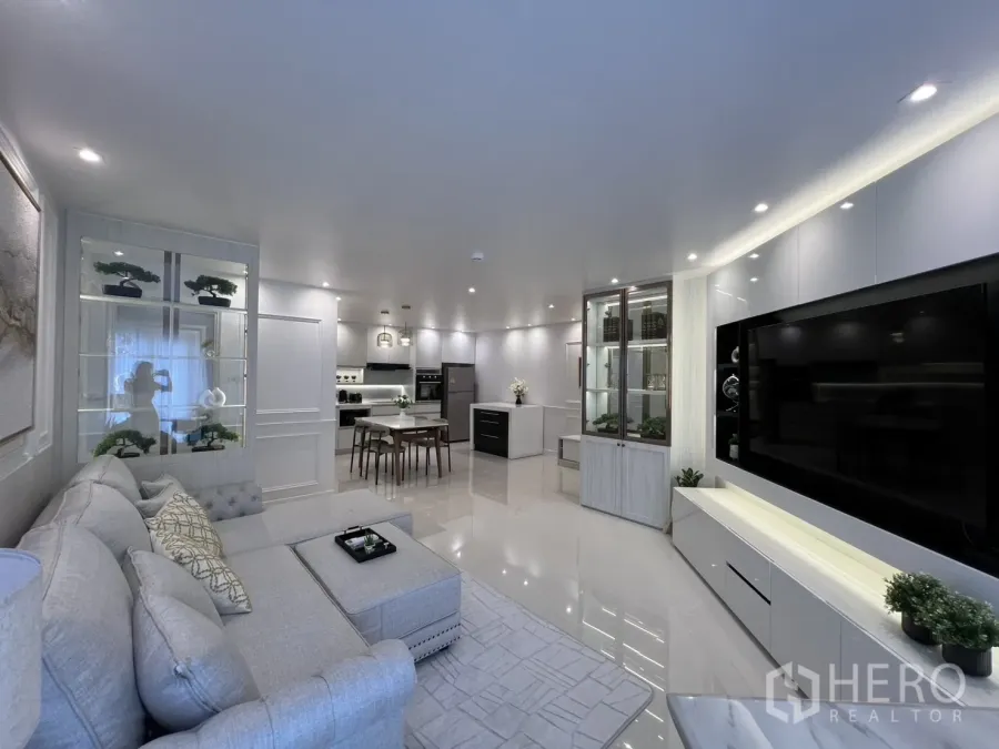Condominium for rent in Yan Nawa, Bangkok - Open-plan lounge and kitchen with display cabinets, dining set, and recessed lighting.