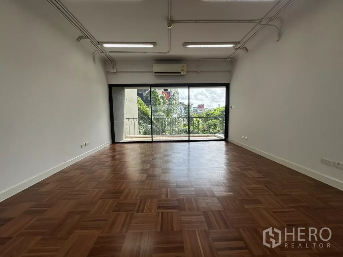สำนักงาน ให้เช่าในWatthana, Bangkok - พื้นที่สำนักงานแบบเปิด พื้นไม้ปาร์เกต์ แอร์แบบแยก และประตูกระจกบานเลื่อนเชื่อมระเบียงพร้อมวิวเมืองและต้นไม้.