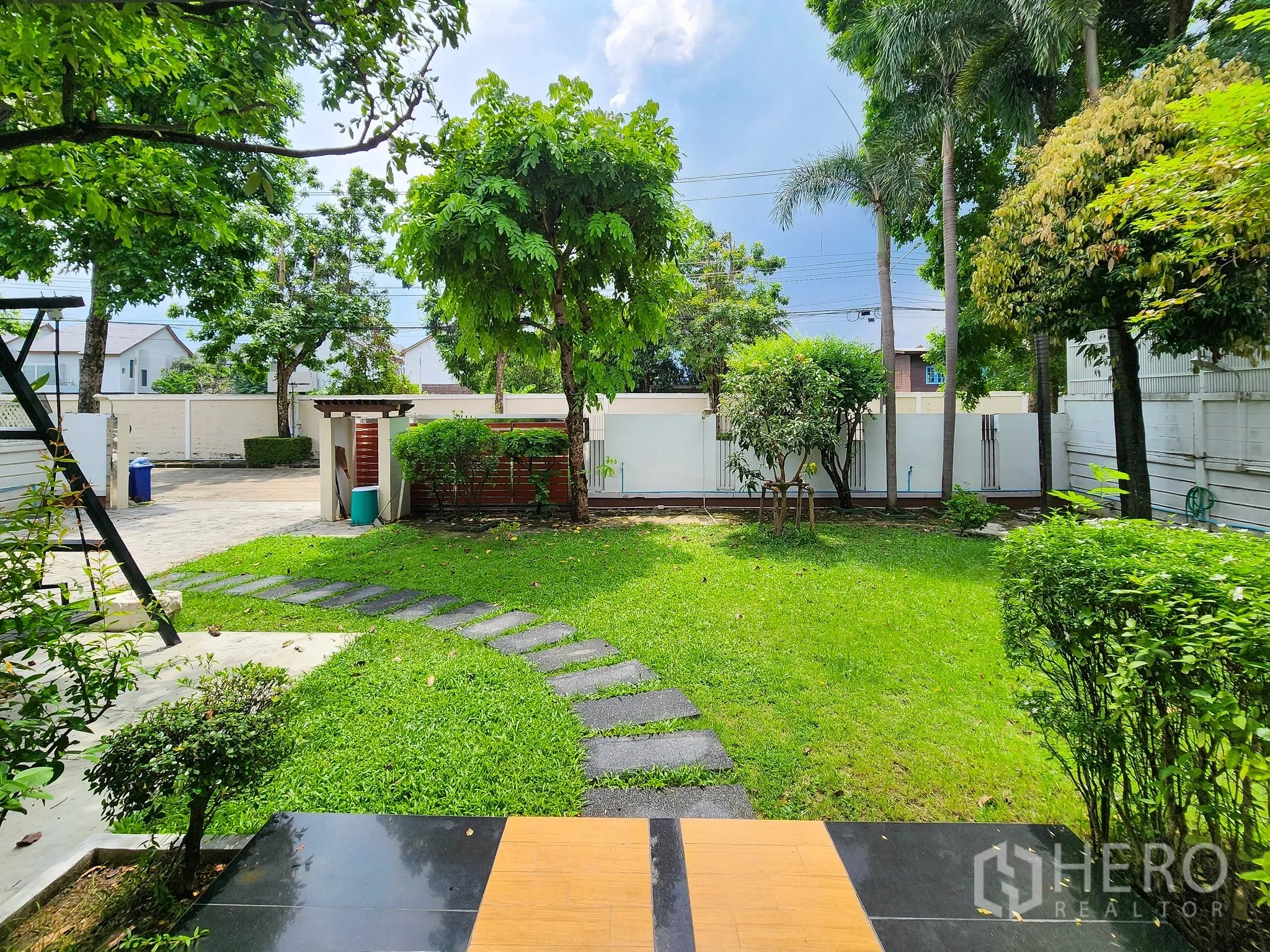 Detached House for rent in Bang Kapi, Bangkok - Spacious private yard with lush lawn, trees and view toward the front gate.