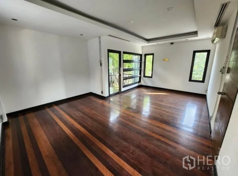 Home Office for rent in Lat Phrao, Bangkok - Large flexible room with multiple windows, balcony access and recessed ceiling details.