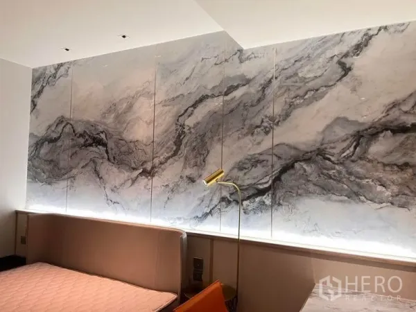 Condominium for rent in Khlong Toei, Bangkok - Feature marble wall with warm backlighting above a headboard, paired with a brass reading lamp.