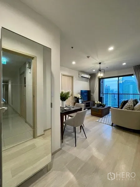 公寓 出租在Pathum Wan, Bangkok - 入户走廊设全身镜，通向明亮客厅与观景阳台。