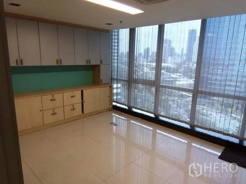 Office Space for rent - Room with long built-in cabinets and full-height windows with city outlook and vertical blinds.