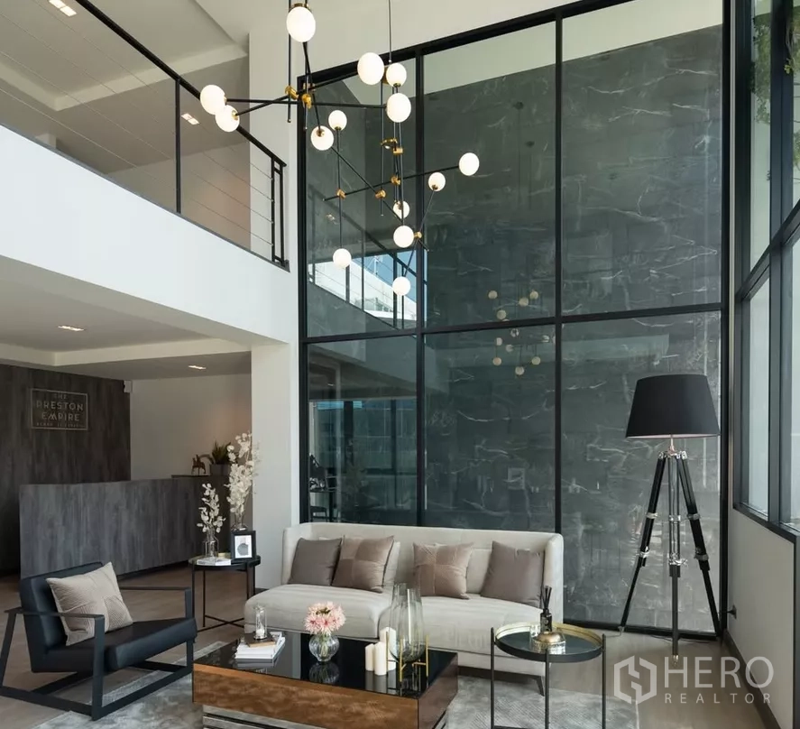 Home Office for sale in Bang Kapi, Bangkok - Stylish lounge and reception area with glass partition, sofa set, and statement lighting.