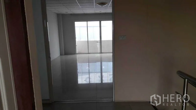 办公空间 出租在Bueng Kum, Bangkok - 走廊望向明亮办公室，亮面地砖与阳台门。