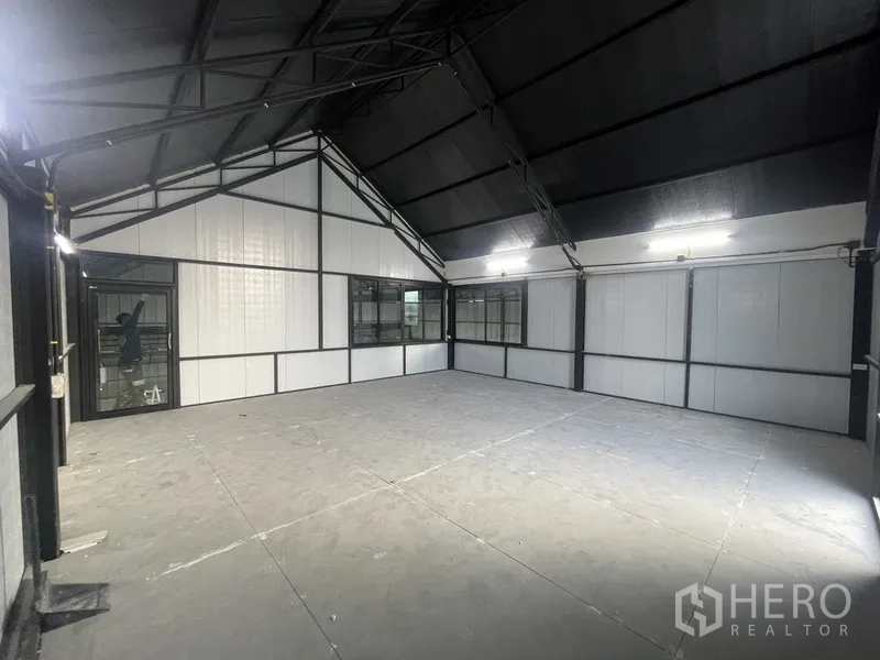 Warehouse for rent in Bueng Kum, Bangkok - Upper mezzanine office area with windows and partition walls beneath a pitched roof.