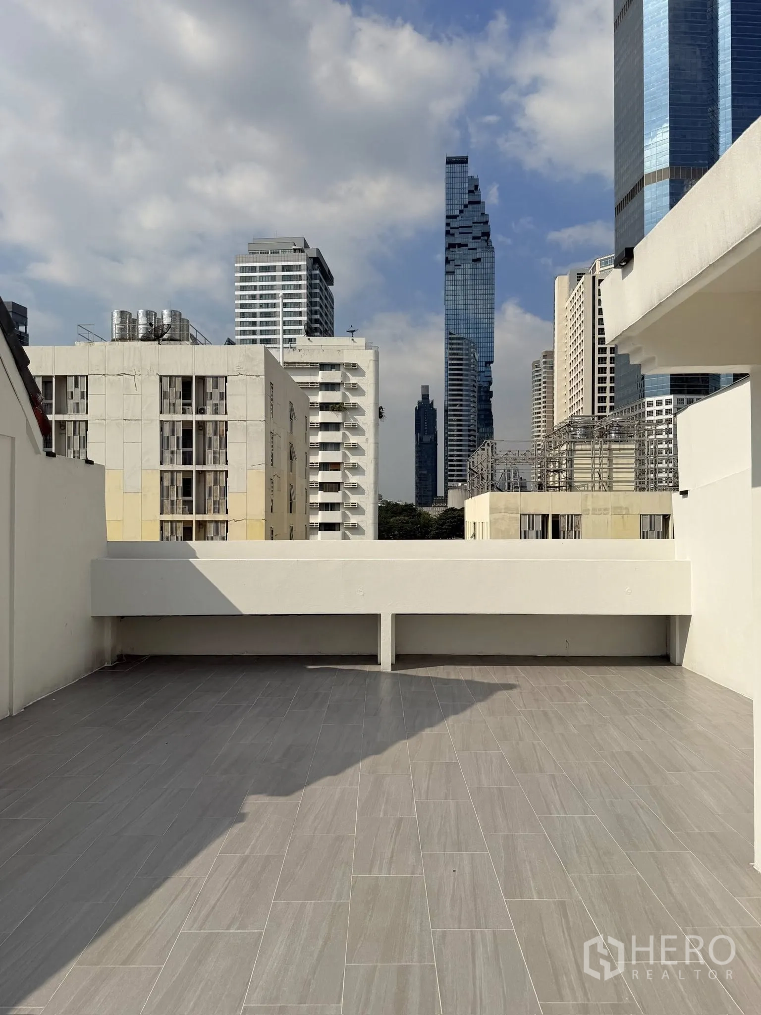 Townhouse for rent or sale in Yan Nawa, Bangkok - Spacious rooftop terrace with tile flooring and city skyline views.