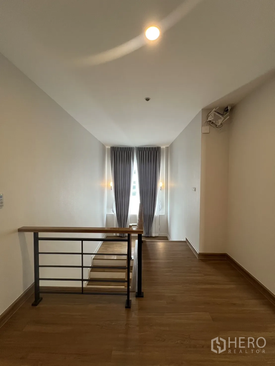 独栋房屋 for rent in Lat Krabang, Bangkok - 楼梯平台带金属栏杆与短阶梯，尽端为落地窗帘。