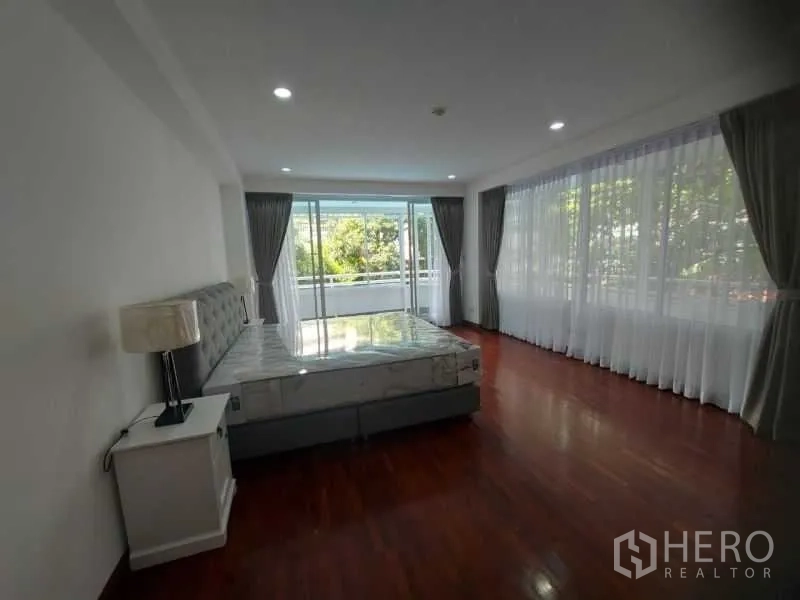 คอนโด ให้เช่าในWatthana, Bangkok - ห้องนอนมุมกระจกสูงจรดเพดาน ประตูกระจกสไลด์ออกระเบียง เห็นวิวต้นไม้