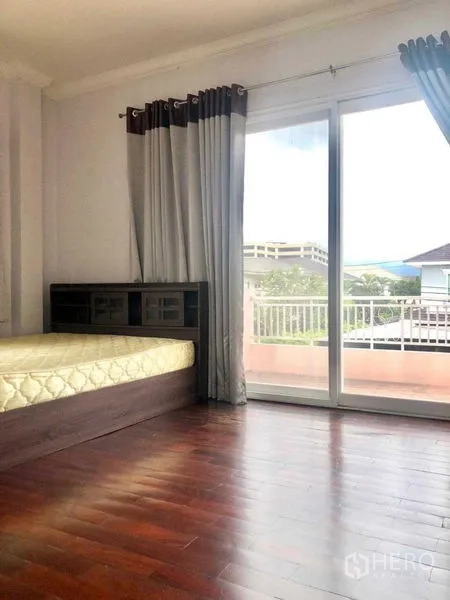 独立式住宅 出售在Lat Krabang, Bangkok - 明亮卧室，木地板，推拉落地门通向阳台。