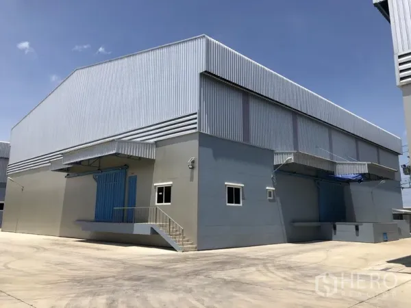 คลังสินค้า ให้เช่าในLat Lum Kaeo, Pathum Thani - อาคารโกดังสมัยใหม่กรุผนังเมทัลชีท พร้อมลานคอนกรีตกว้างและท่าขนถ่ายมีหลังคา ใต้ท้องฟ้าโปร่ง.